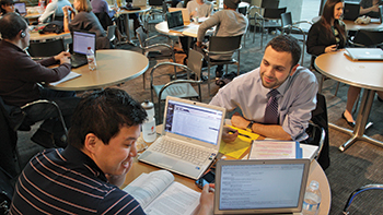 Law students studying together at a table with laptop computers