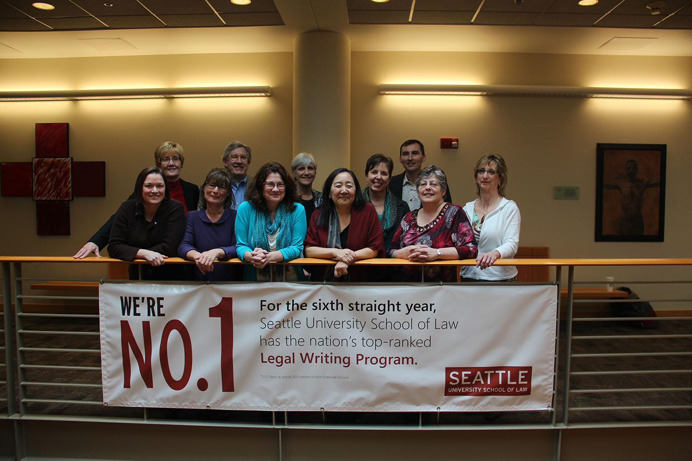 Legal writing team behind a banner with text 