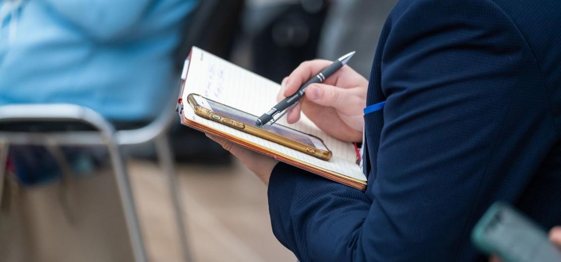 A man using a stylus to write on his phone