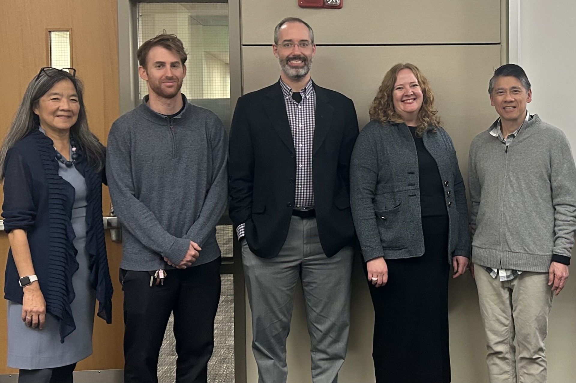 TILE Director Maggie Chon, Professor Mark Verstraete, Adjunct Professor Jake Bernstein ('07), Cari Benn ('05), and Adjunct Professor Chris Koa posing in front of a whiteboard.