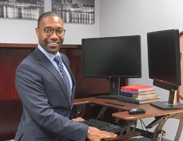 Azar Alexander '16 in front of a desk