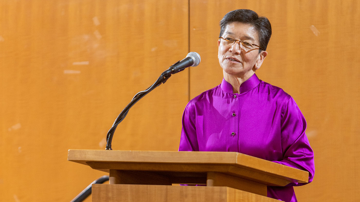 Justice Mary Yu speaking in front of a podium