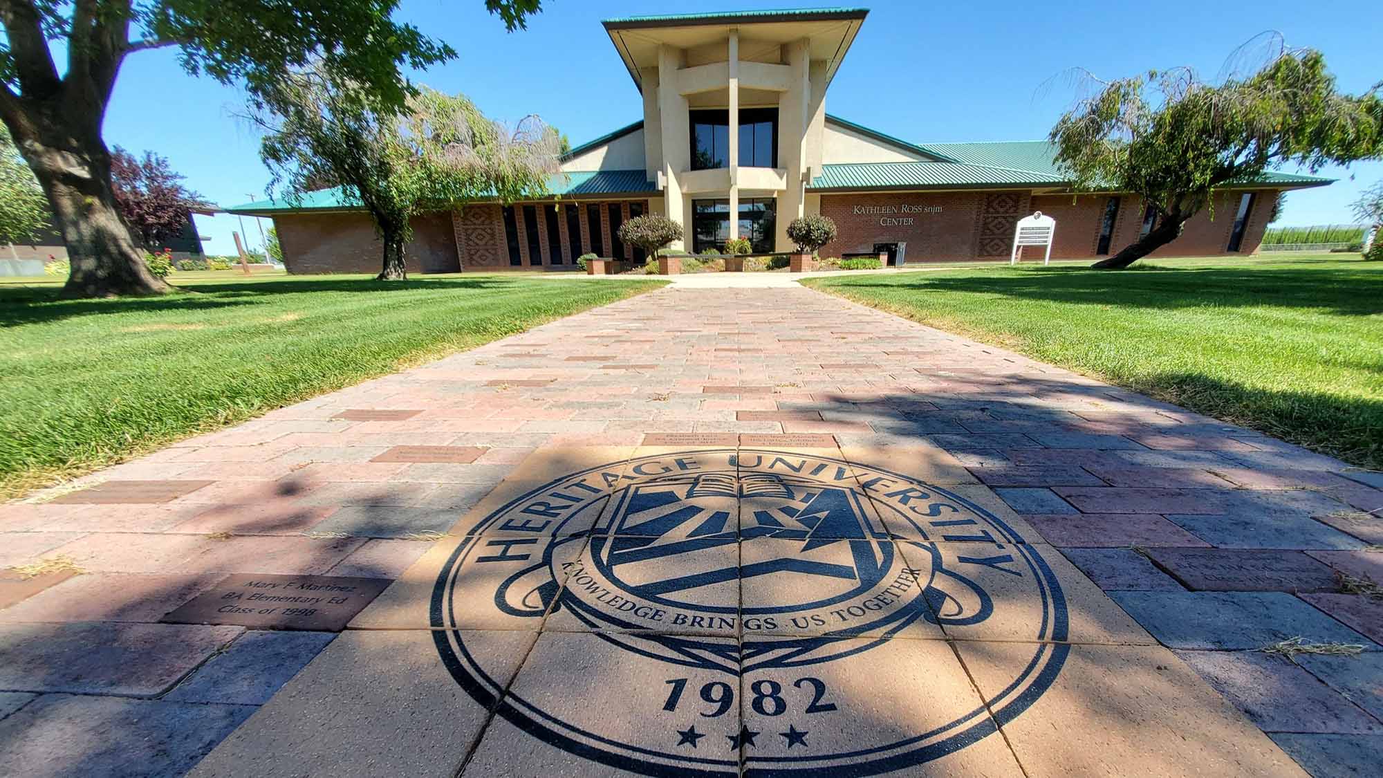 The Ross Center at Heritage University with the Heritage University seal on the walkway