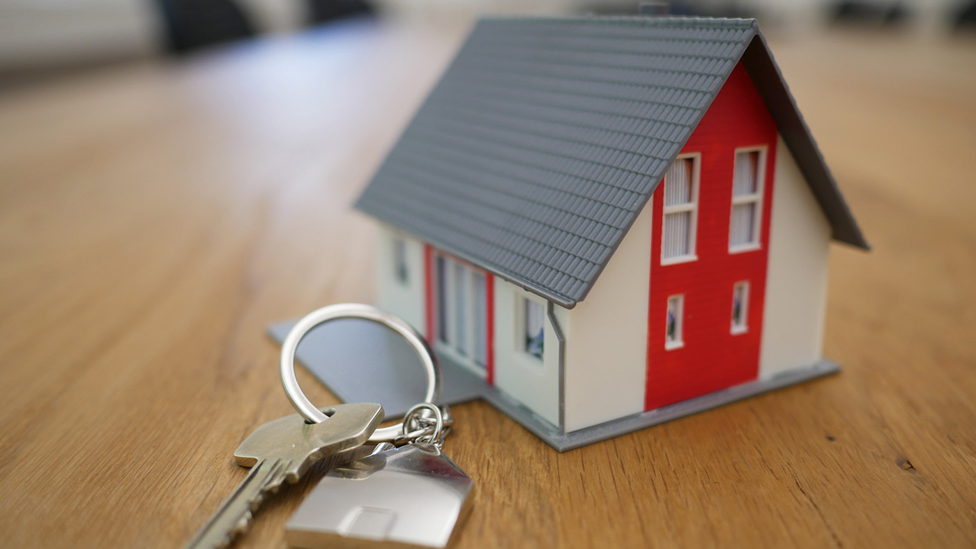 A tiny model of a house and a set of keys