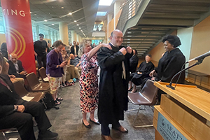 Leonard J. Feldman dons his judicial robe with help from his wife, Kristine, during a ceremony celebrating his appointment to the Washington State Court of Appeals, Division One.
