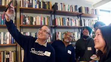 Dean Varona shoots a selfie with guests at a community brunch