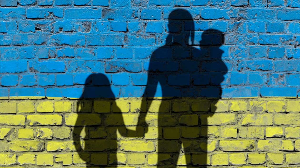 Silhouette of refugee family against blue and yellow stone wall