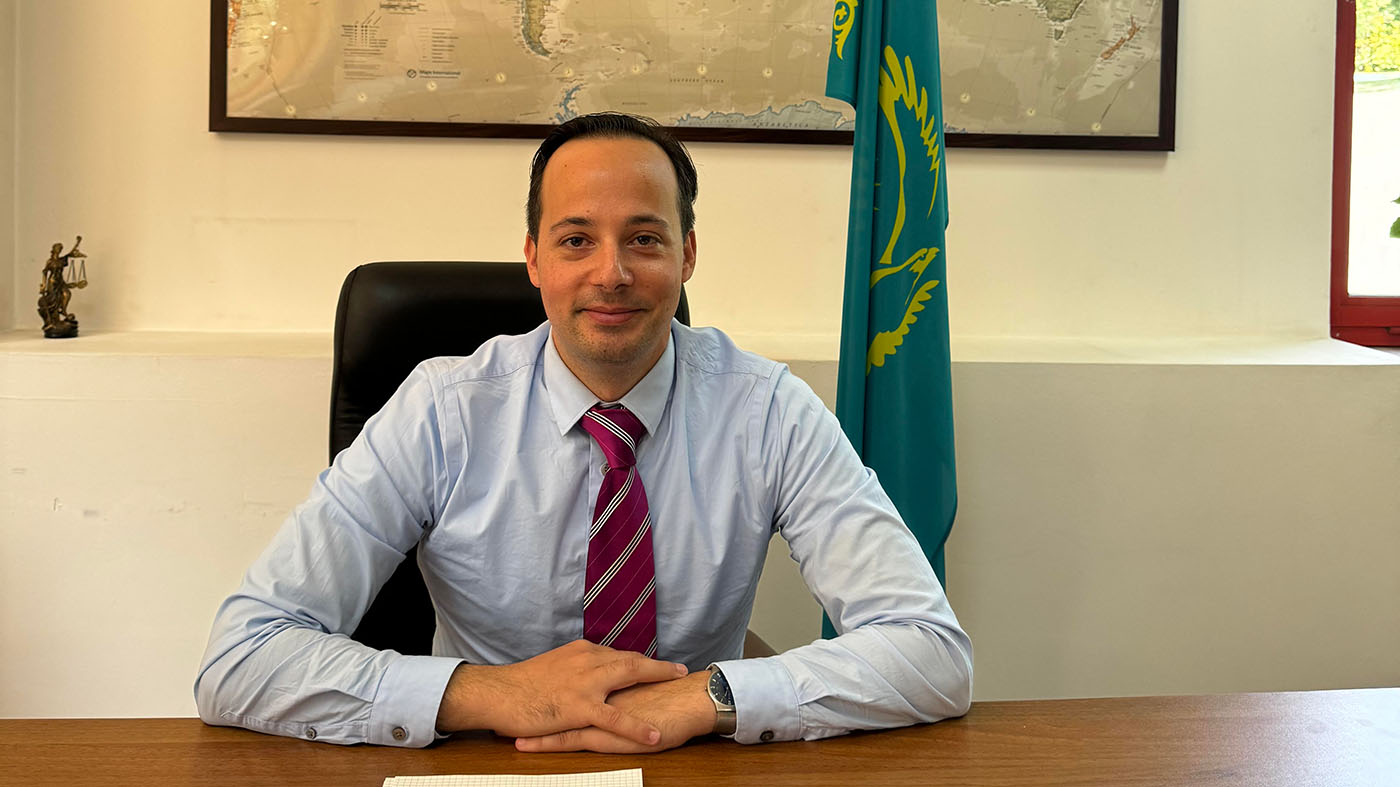 Professor Michael Blasie at a desk with the flag of Kazakhstan