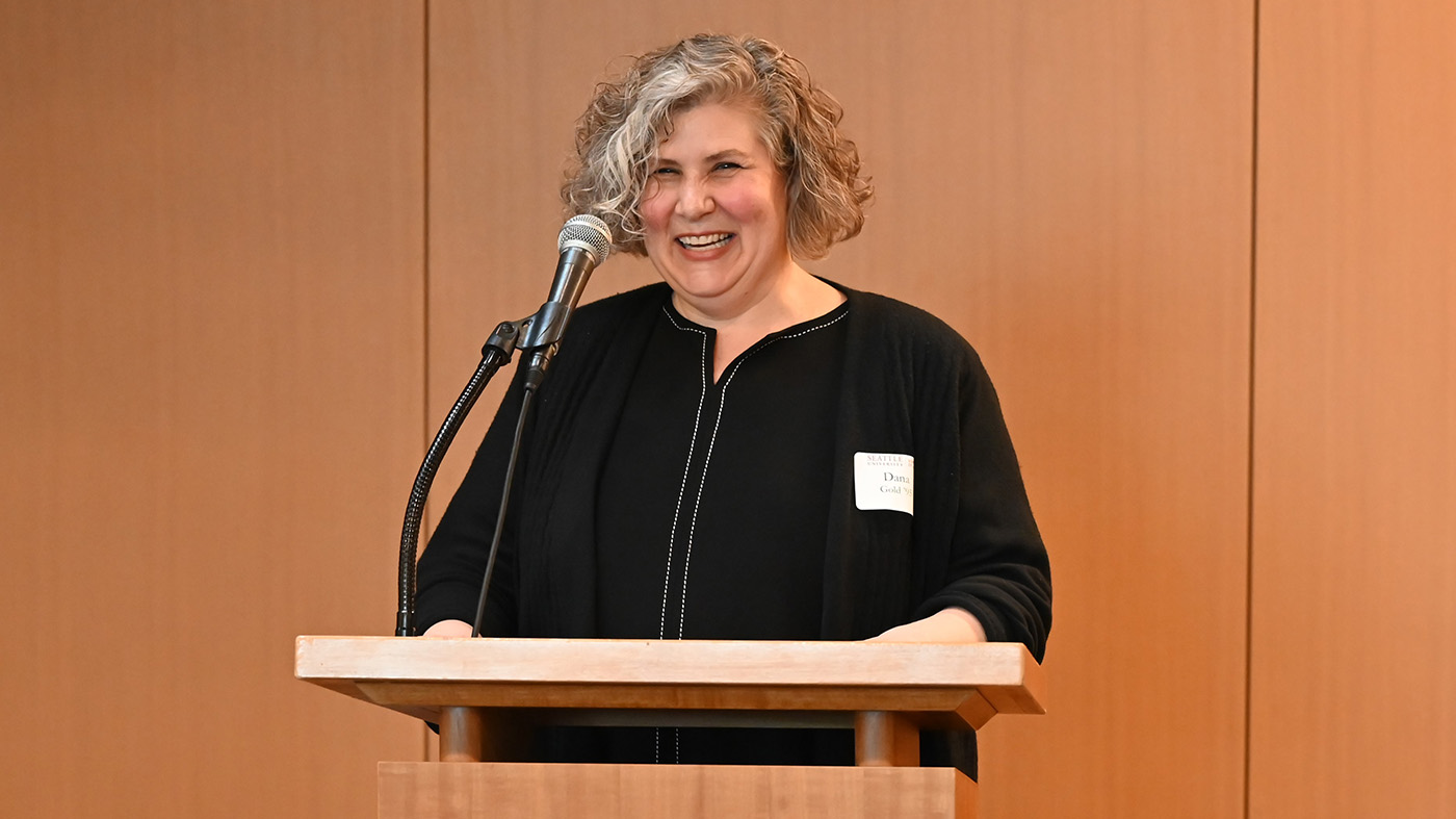 Woman of the Year Dana Gold standing at a podium making a speech